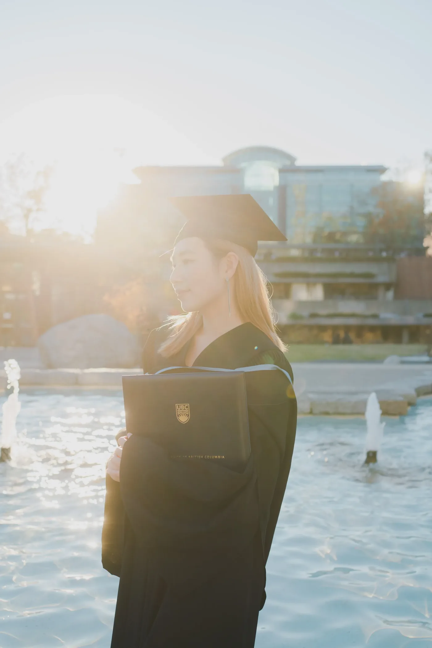 UBC graduate portrait in cap and gown at Main Mall