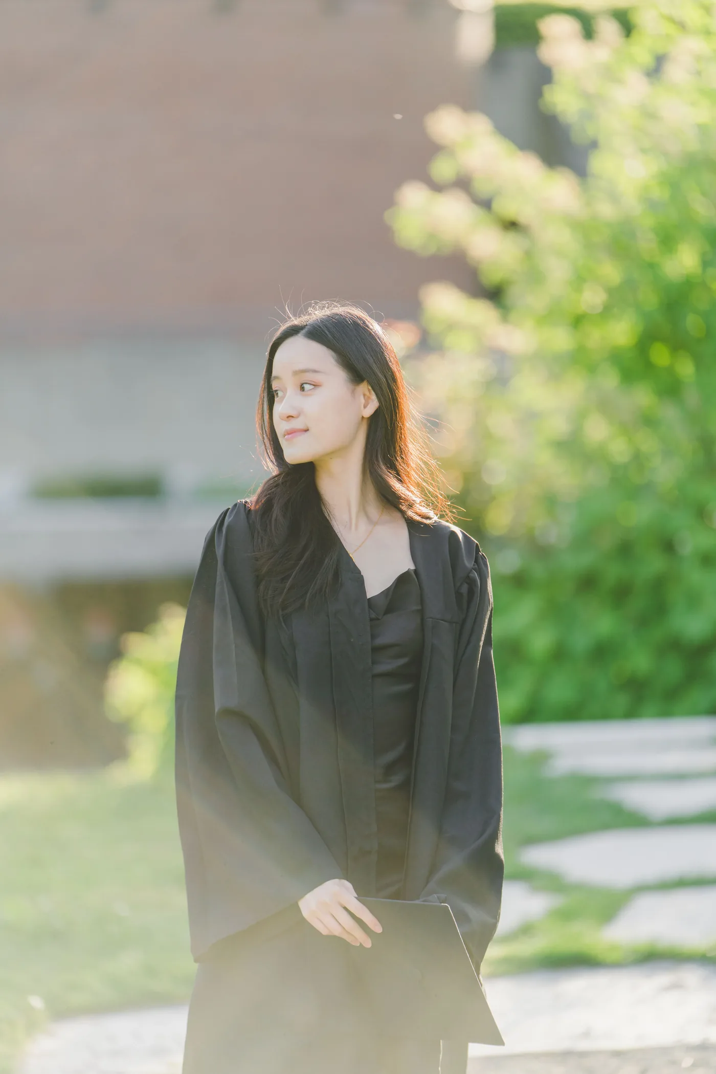 UBC graduate in cap and gown on campus